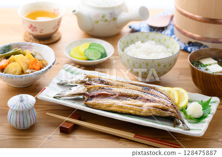 熱騰騰的日式早餐：桌上的烤魚（秋刀魚片）、米飯和味噌湯 128475887