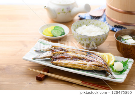 熱騰騰的日式早餐：桌上的烤魚（秋刀魚片）、米飯和味噌湯 128475890