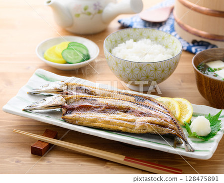 熱騰騰的日式早餐：桌上的烤魚（秋刀魚片）、米飯和味噌湯 128475891
