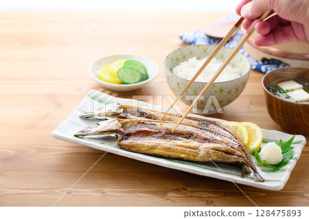 熱騰騰的日式早餐：桌上的烤魚（秋刀魚片）、米飯和味噌湯 128475893