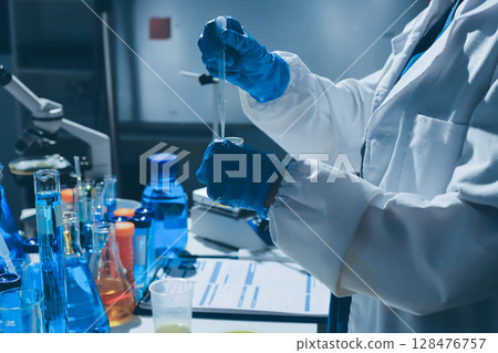 Scientist pipetting medical samples into microplate in laboratory Scientist pipetting medical samples into microplate in laboratory 128476757