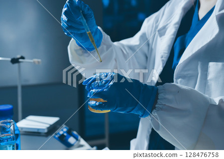 Scientist pipetting medical samples into microplate in laboratory Scientist pipetting medical samples into microplate in laboratory 128476758