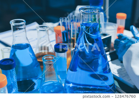 Scientist pipetting medical samples into microplate in laboratory 128476760