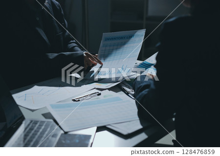 Group of business women working on a financial data expenses document. Group of business women working on a financial data expenses document. 128476859