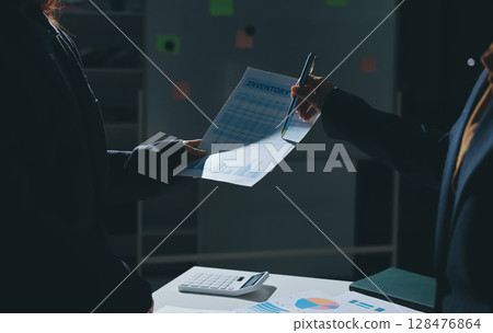 Group of business women working on a financial data expenses document. Group of business women working on a financial data expenses document. 128476864