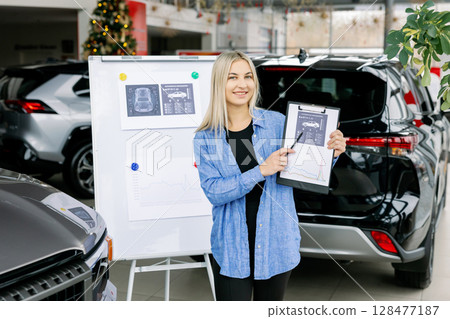 Saleswoman showing infographic during presentation about automotive suspension performance in car dealership Saleswoman showing infographic during presentation about automotive suspension performance in car dealership 128477187