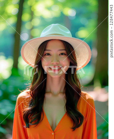 穿著橘色襯衫的年輕女子在森林裡享受健行 128477443