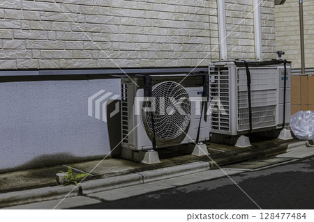 Air conditioner, outdoor unit with sunshade, night, residential area 128477484