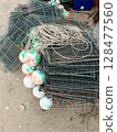 Pile of Fishing Traps with Buoys on Sandy Ground. 128477560