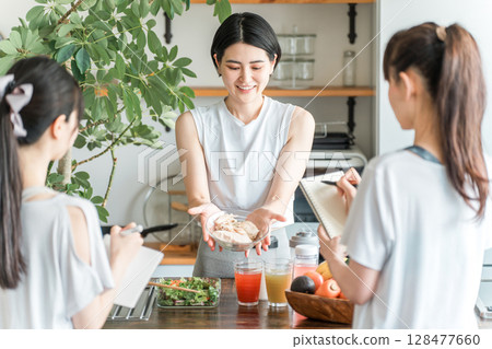 A female athlete teaching muscle-building chicken dishes at a cooking class, Athlete Food My Meister 128477660