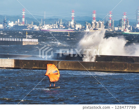 Coastal scenery with strong winds, rough waves and wing surfing 128477799