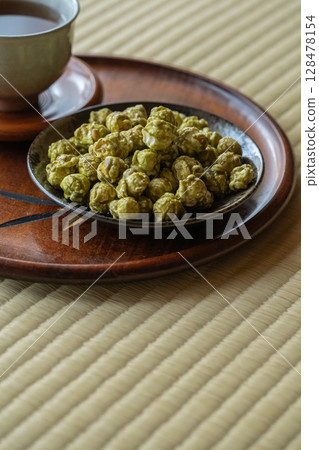 在日式房間的榻榻米上享用抹茶爆米花和日本茶 在日式房間的榻榻米上享用抹茶爆米花和日本茶 128478154