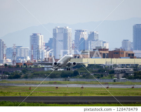 從伊丹機場起飛的客機和大阪的建築物 128478479
