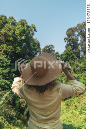Woman in Straw Hat Admiring Tropical Forest View 128478558