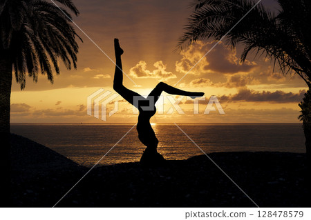 Yoga Silhouette at Sunset by the Sea. Mindfulness and Harmony 128478579