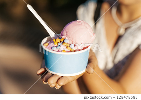 Strawberry Ice Cream Cup with Sprinkles in Hand at City Park Strawberry Ice Cream Cup with Sprinkles in Hand at City Park 128478583