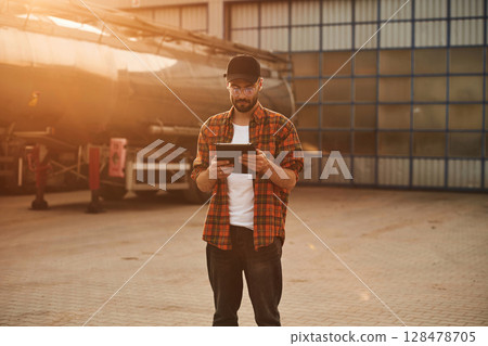 Digital tablet in hands. Young truck driver in casual clothes 128478705