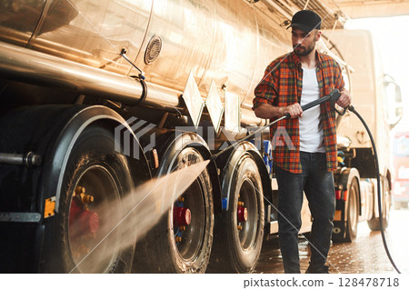 Washing the vehicle. Young truck driver in casual clothes Washing the vehicle. Young truck driver in casual clothes 128478718