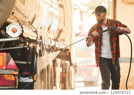 Process of washing the vehicle. Young truck driver in casual clothes Process of washing the vehicle. Young truck driver in casual clothes 128478721