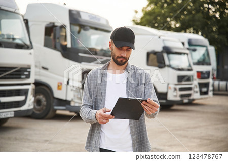 Manager is with notepad. Young truck driver in casual clothes Manager is with notepad. Young truck driver in casual clothes 128478767