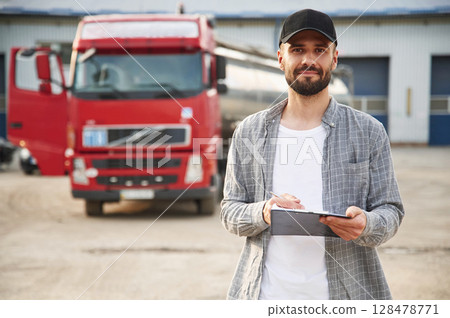 Manager is with notepad. Young truck driver in casual clothes 128478771