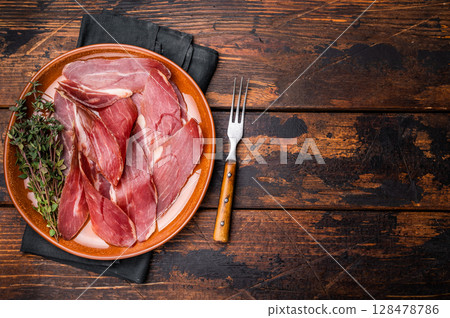 Tyrolean raw ham Speck, Italian sliced cured pork meat. wooden background. top view 128478786