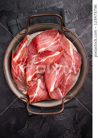 Thin slices of Speck, Jambon Italian cured meat. black background. top view 128478796