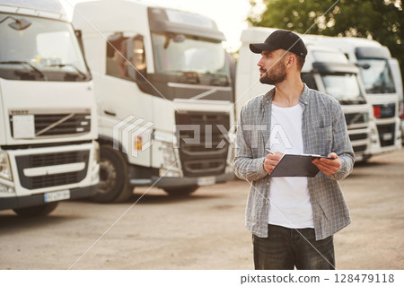 Notepad in hands. Young truck driver in casual clothes Notepad in hands. Young truck driver in casual clothes 128479118
