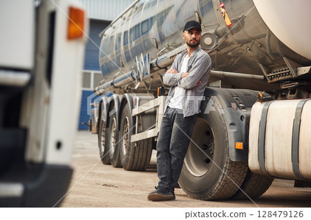 Leaning on the vehicle. Young truck driver in casual clothes 128479126