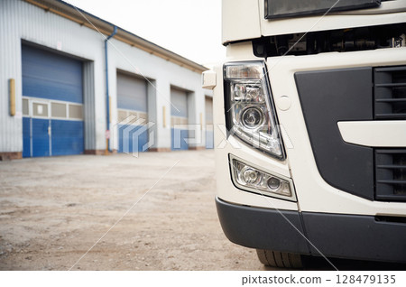 Front particle view of truck that is parked outdoors near garage 128479135