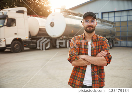 Standing with arms crossed. Young truck driver in casual clothes 128479184