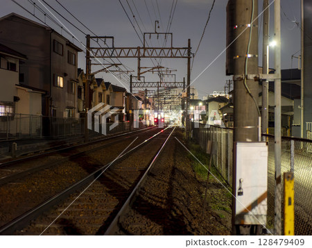 Train running through a residential area at night Train running through a residential area at night 128479409