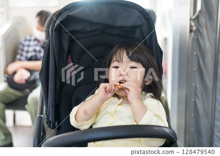 Girl eating snack on train Girl eating snack on train 128479540