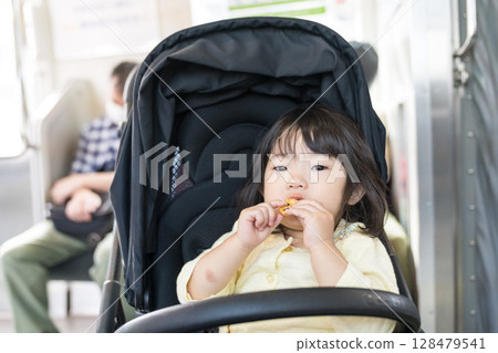 Girl eating snack on train Girl eating snack on train 128479541