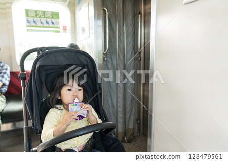 Girl eating snack on train 128479561