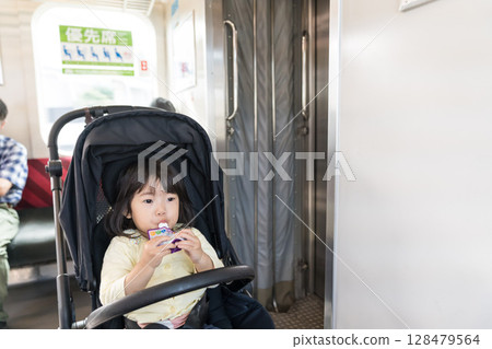 Girl eating snack on train Girl eating snack on train 128479564