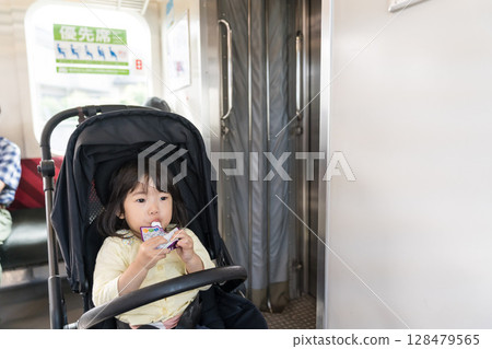 Girl eating snack on train Girl eating snack on train 128479565