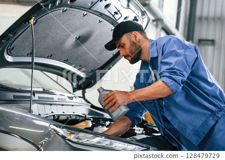 Process of changing the oil. Auto mechanic working in garage. Repair service Process of changing the oil. Auto mechanic working in garage. Repair service 128479729