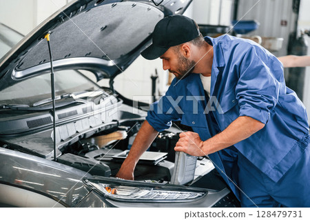 Process of changing the oil. Auto mechanic working in garage. Repair service 128479731