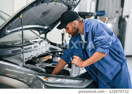 Process of changing the oil. Auto mechanic working in garage. Repair service 128479732