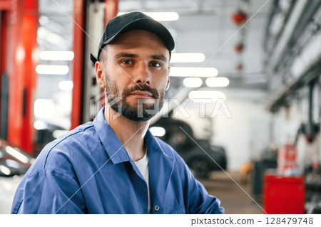 Portrait of auto mechanic that is in garage. Repair service Portrait of auto mechanic that is in garage. Repair service 128479748