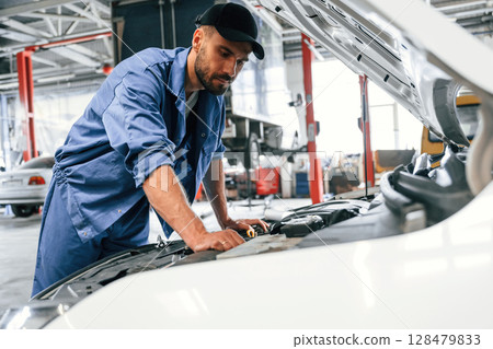 Troubleshooting process. Auto mechanic working in garage. Repair service Troubleshooting process. Auto mechanic working in garage. Repair service 128479833