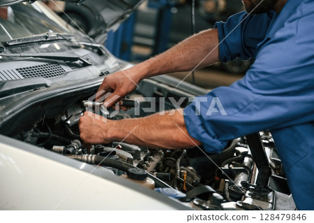 Repair service. Auto mechanic working in garage 128479846