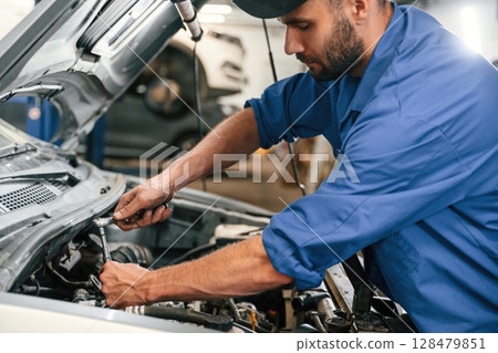 Repair service. Auto mechanic working in garage 128479851