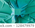 Cubic pedestal covered by green soft fabric 128479979