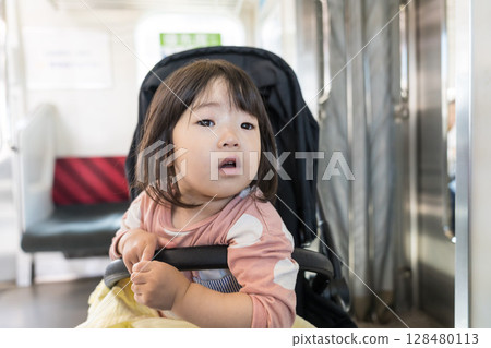 Girl in a stroller on the train 128480113
