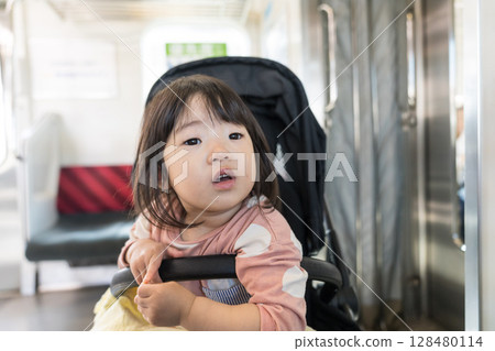Girl in a stroller on the train 128480114
