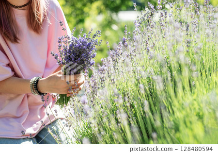 Woman holding lavender bouquet in blooming field 128480594