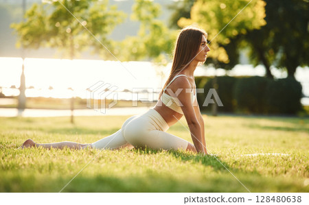 In the park at sunny daytime. Beautiful young woman in sportive clothes 128480638