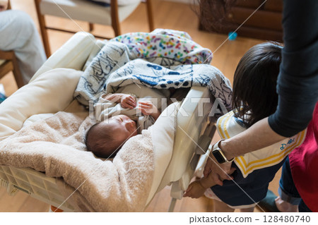 Japanese baby and family sleeping in a baby chair at home 128480740